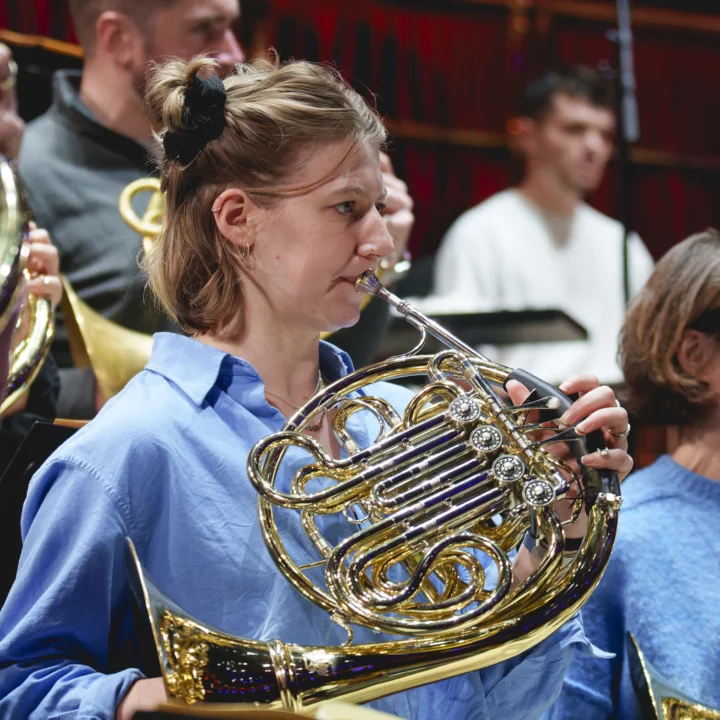 Zoë Tweed playing horn in rehearsal