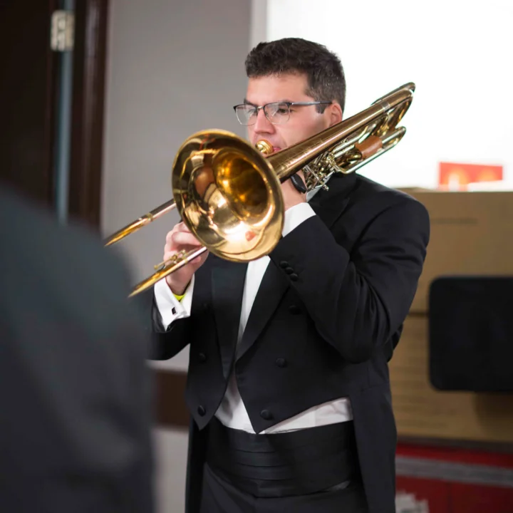 Josh Cirtina playing bass trombone backstage