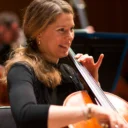 An RPO cellist smiling as she plays