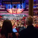 Audience members watching a concert from a box in the Royal Albert Hall