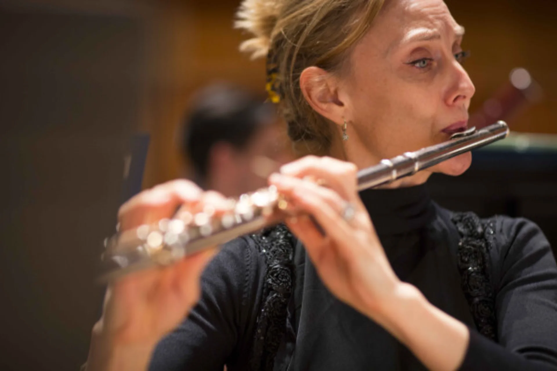 An RPO flautist playing in concert dress