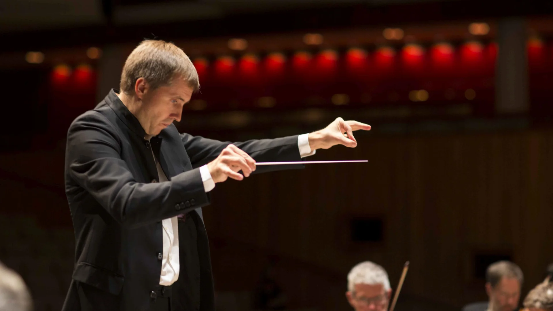Vasily Petrenko conducts the orchestra at the Royal Festival Hall, he is pointing.