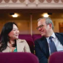 Min Kym and Michael Hayman in the stalls of Cadogan Hall and smiling at each other