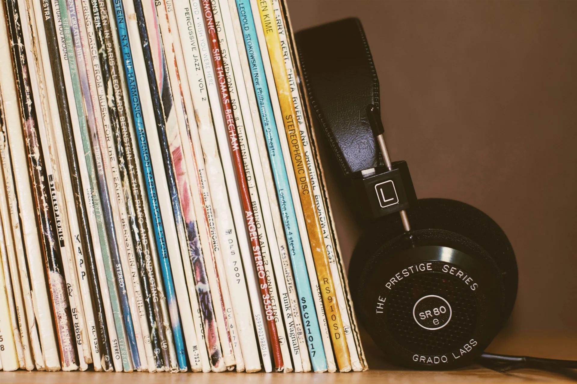 A row of classical vinyls with headphones leaning against them