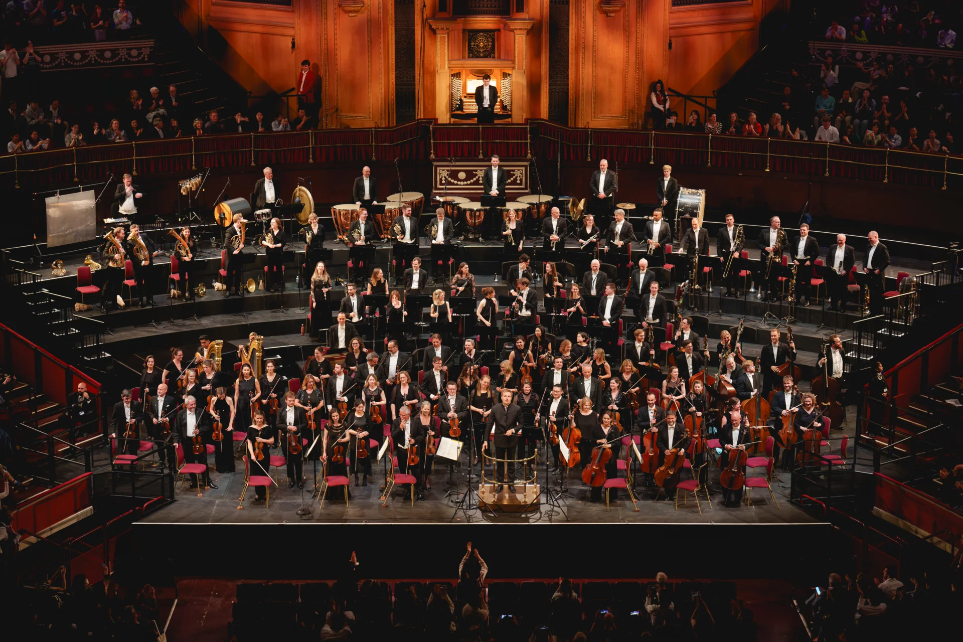 The Orchestra standing on stage to receive applause at the Royal Albert Hall