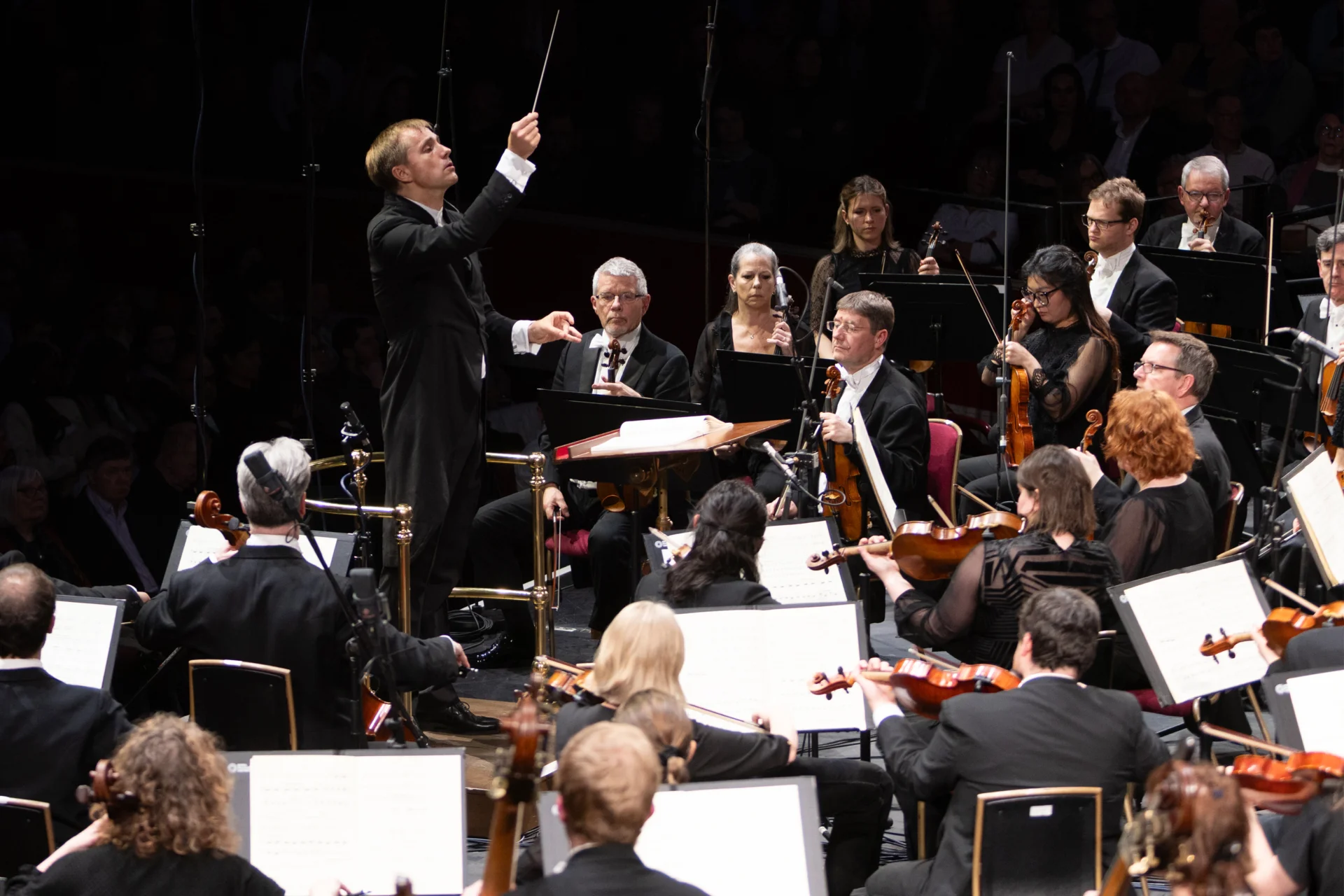 Vasily Petrenko conducting the Orchestra at the Royal Albert Hall. Microphones are dotted around the players.