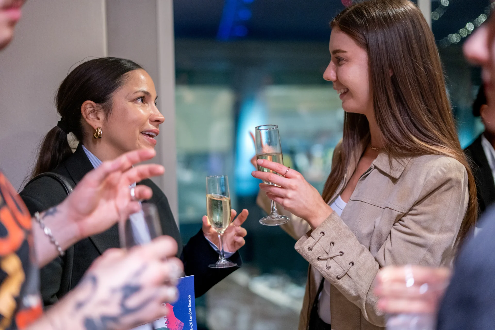 Two people smiling and talking as they drink Chapel Down from glasses