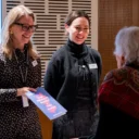 RPO staff at the ticketing desk at Southbank Centre smiling and handing a programme to an audience member