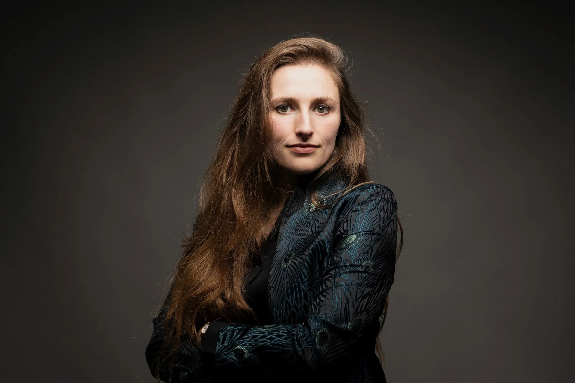 Historian Leah Broad looking at the camera with her arms crossed, wearing a black jacket