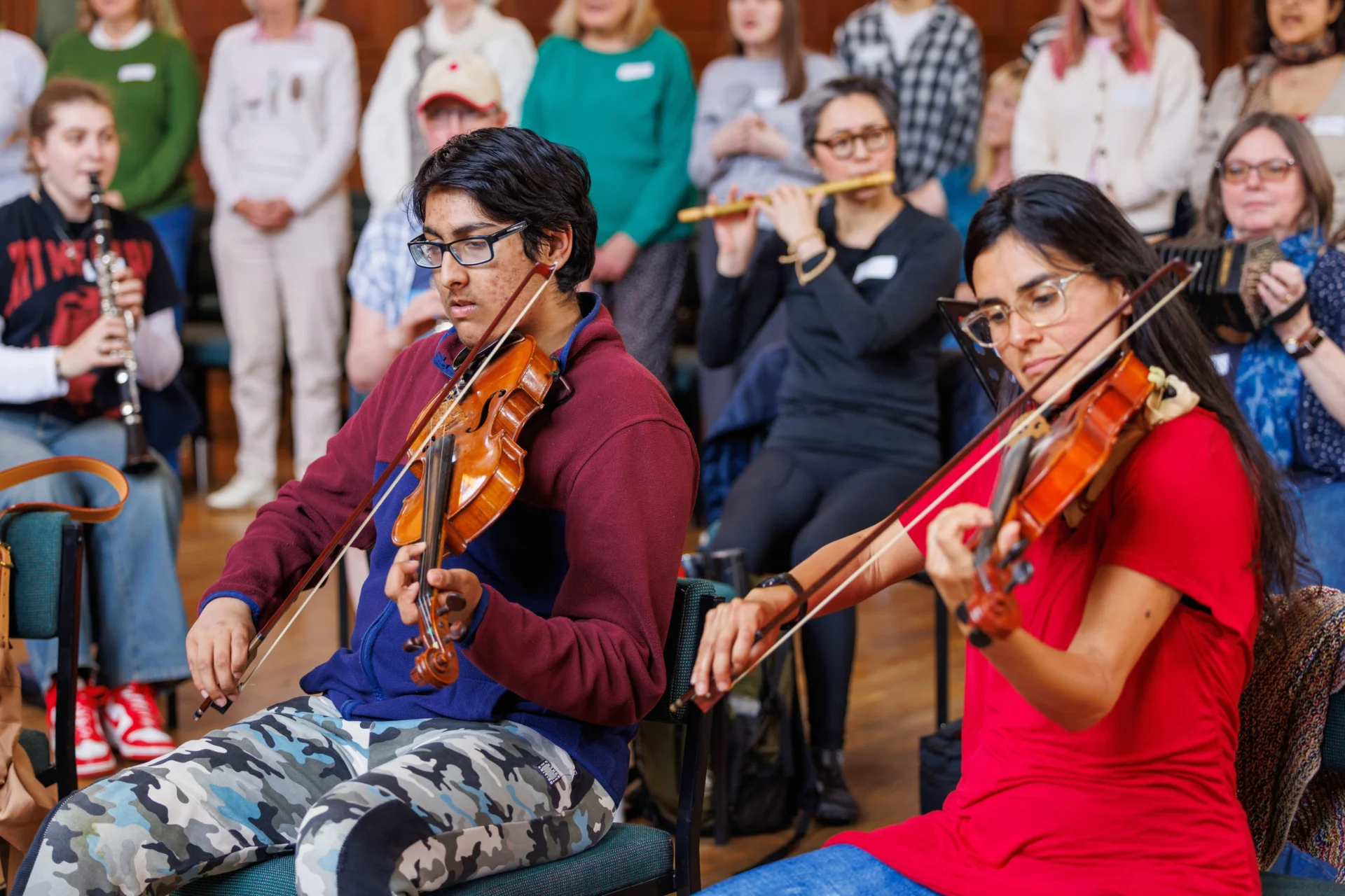 Participants in a Resound workshop play instruments together, smiling