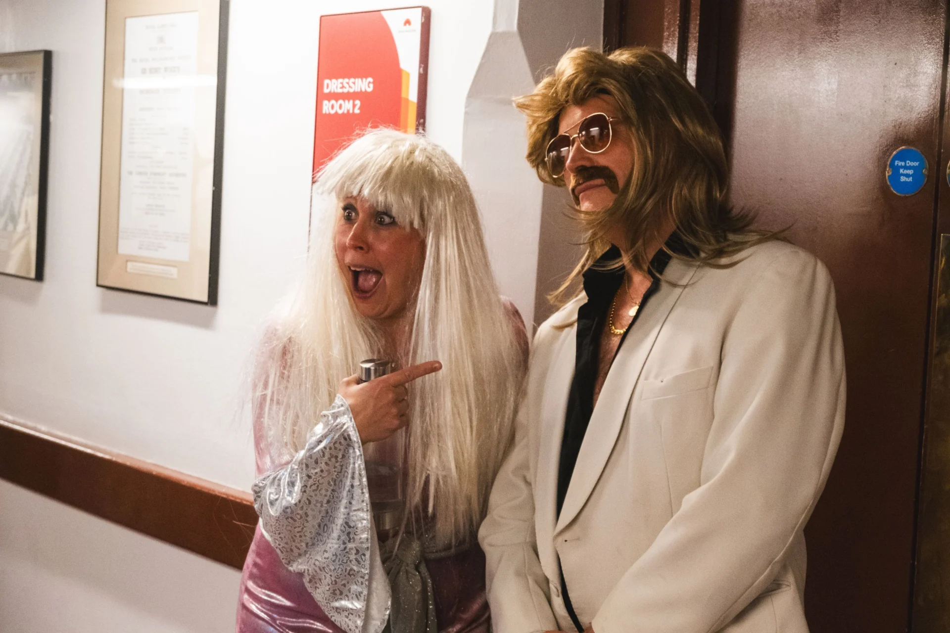 Two Royal Philharmonic Orchestra musicians backstage in full ABBA costumes and wigs