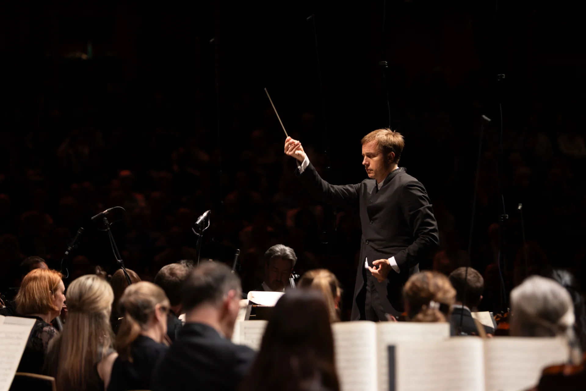 Vasily Petrenko conducting with his baton arm raised and his left land slightly curled