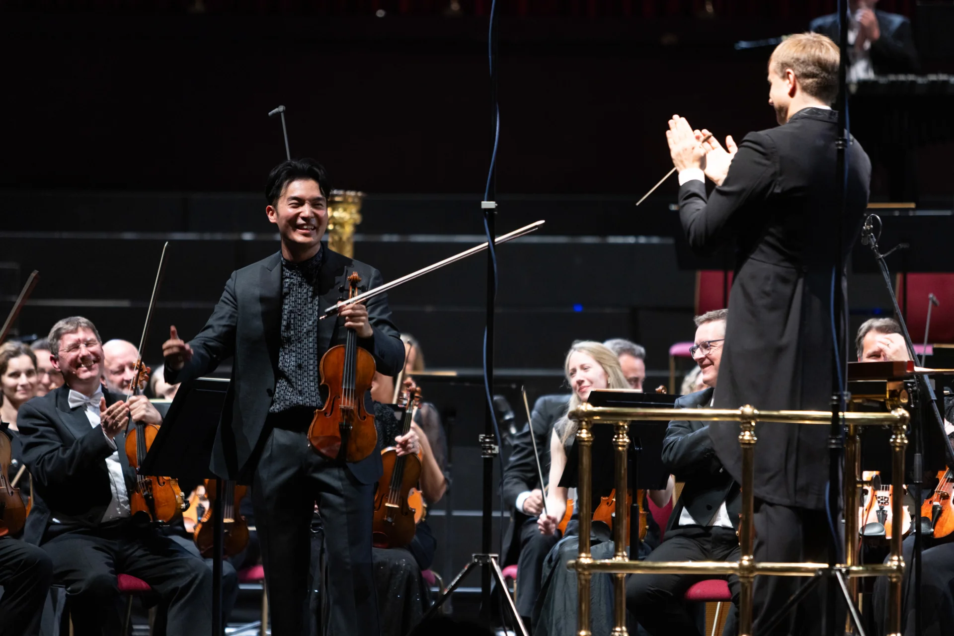 Ray Chen smiling and looking towards Vasily as he applauds