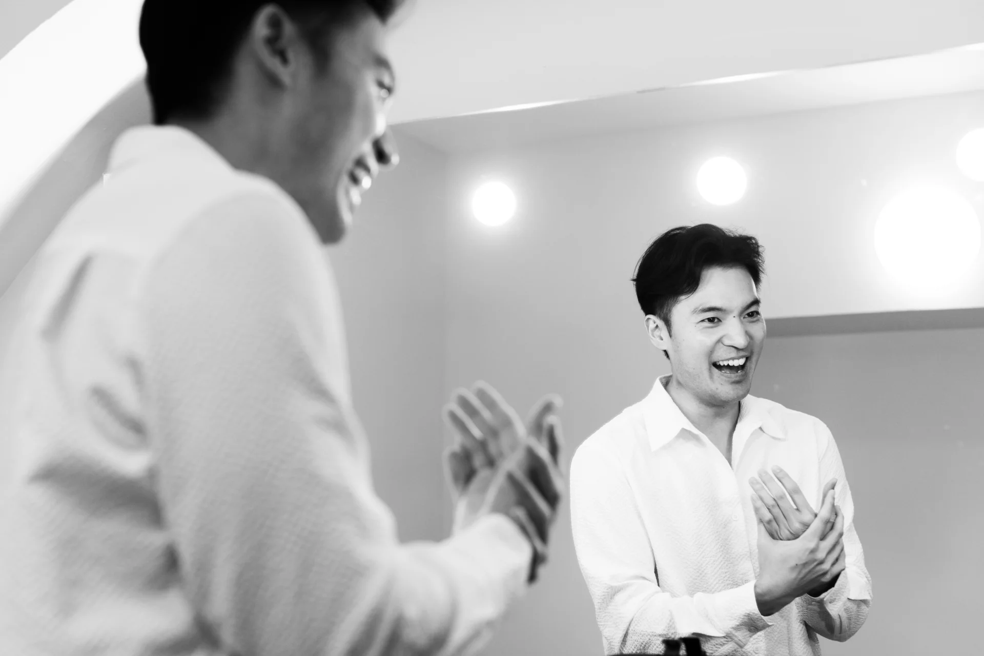 Ray Chen in his dressing room reflected in the mirror and smiling