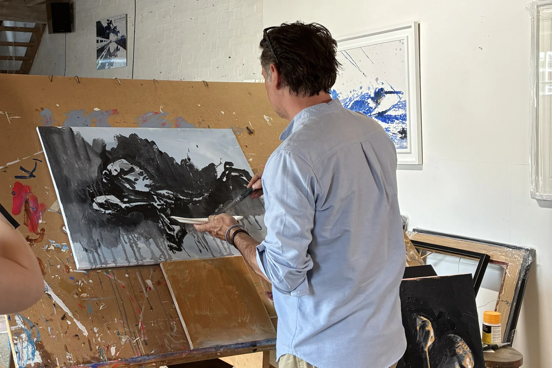 Jeremy Houghton standing and painting black and white portrait in artist's studio