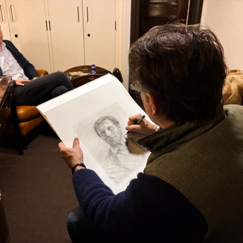Artist Jeremy Houghton seated and sketching in pencil Vasily Petrenko, also seated