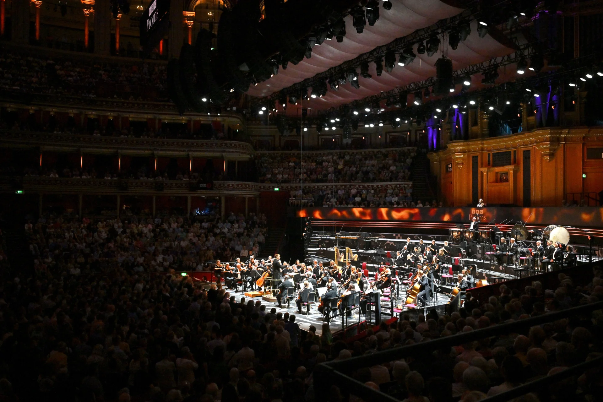 A wide shot from the side of the Orchestra and Pablo Ferrandez performing on stage