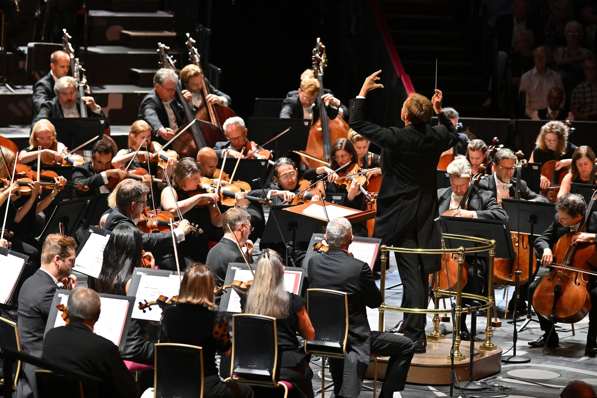 Vasily Petrenko conducting and turned towards the double basses both arms raised