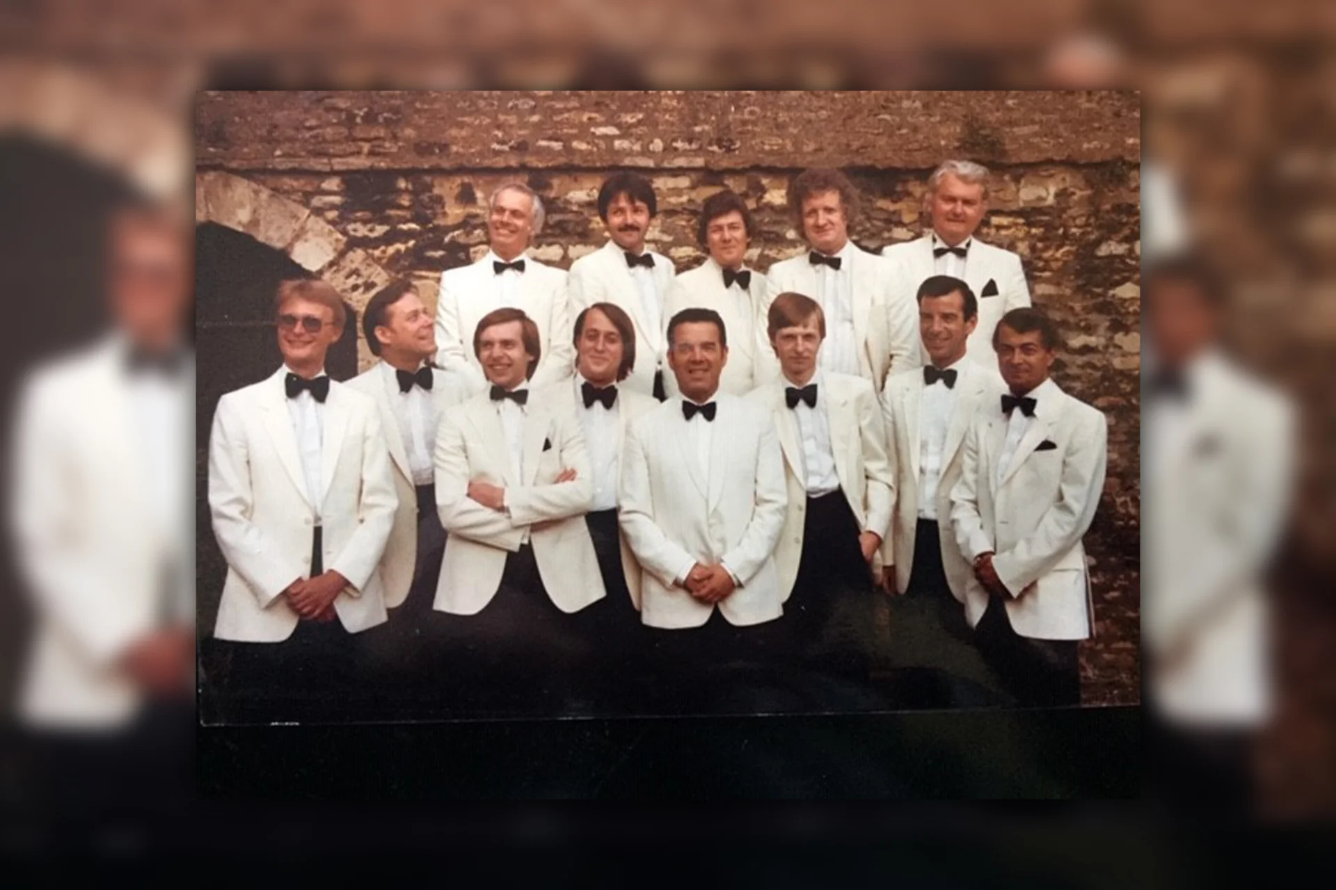 An old photo of two rows of RPO violinists in white suits