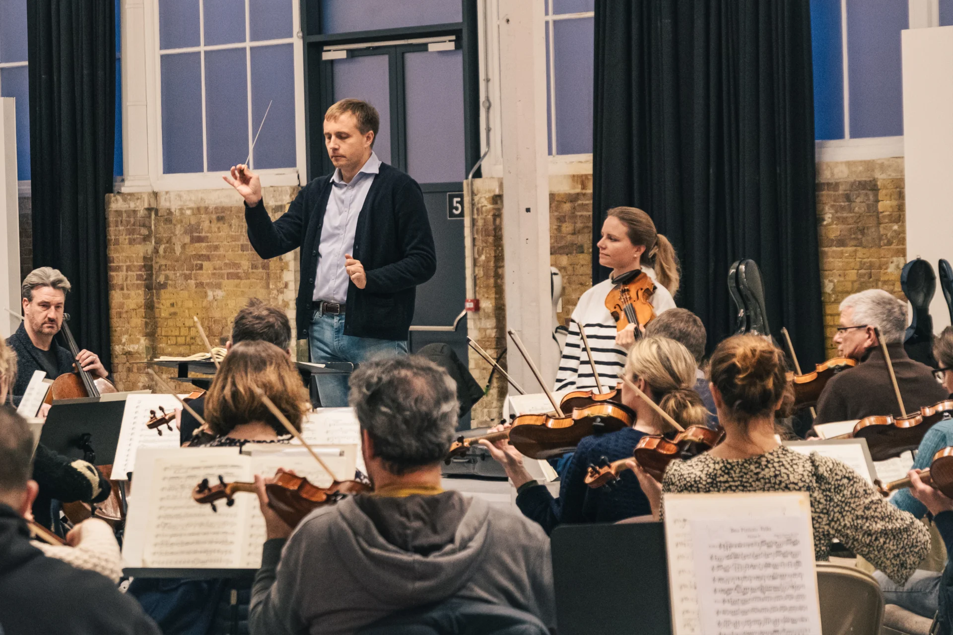 Vasily Petrenko conducting the Orchestra in rehearsal with Julia Fischer beside him