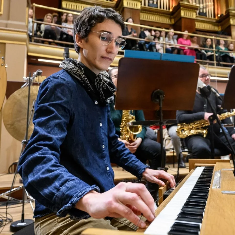 A man plays the piano as part of an orchestra