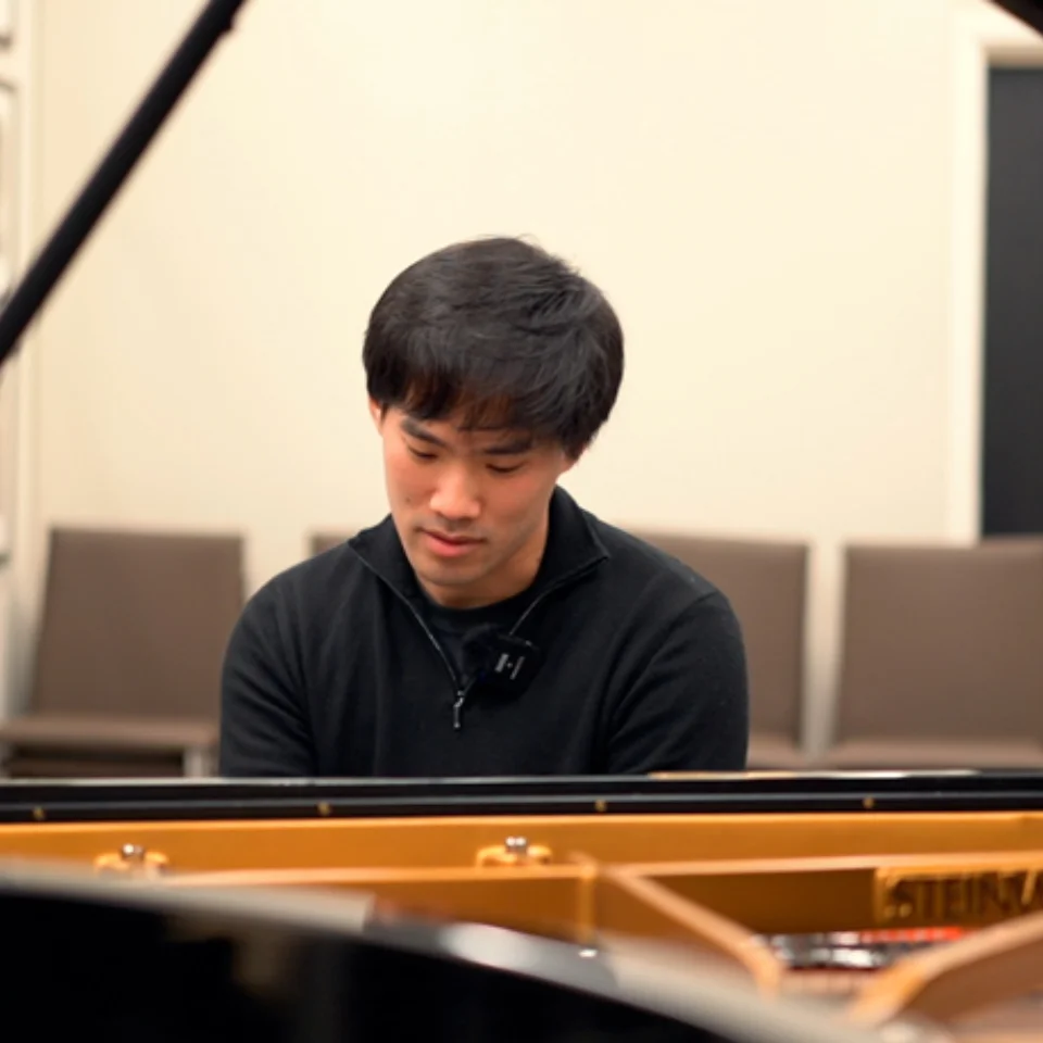 Bruce Liu sitting at a piano