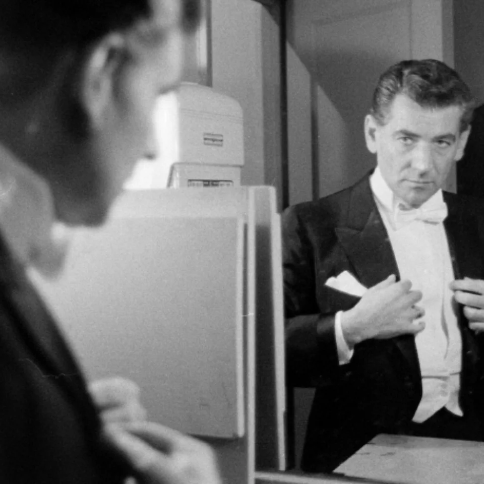 Bernstein in a tuxedo looking at himself in the mirror