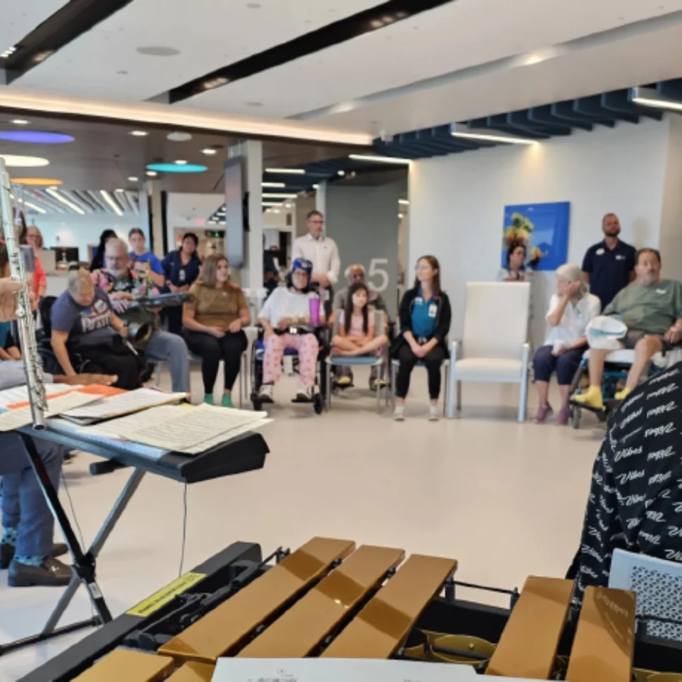 A group of adults playing music together in a circle