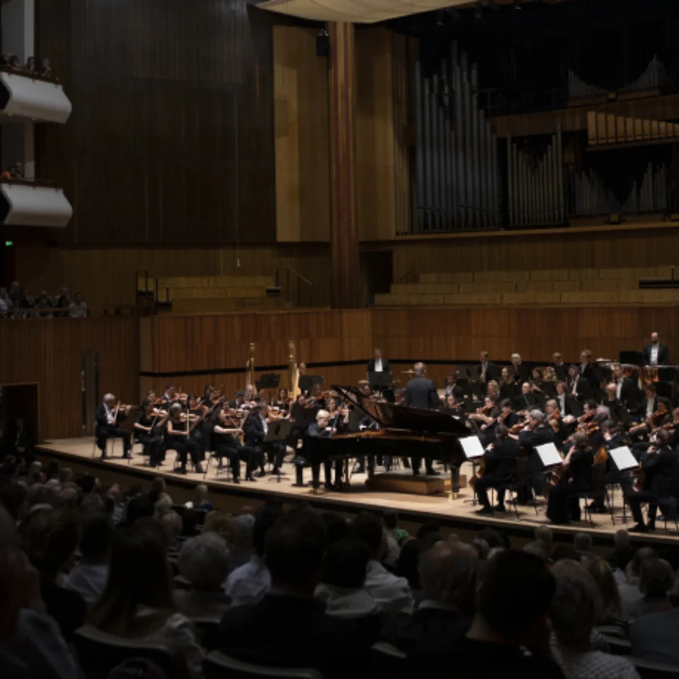 Orchestra playing in front of an audience in a concert hall