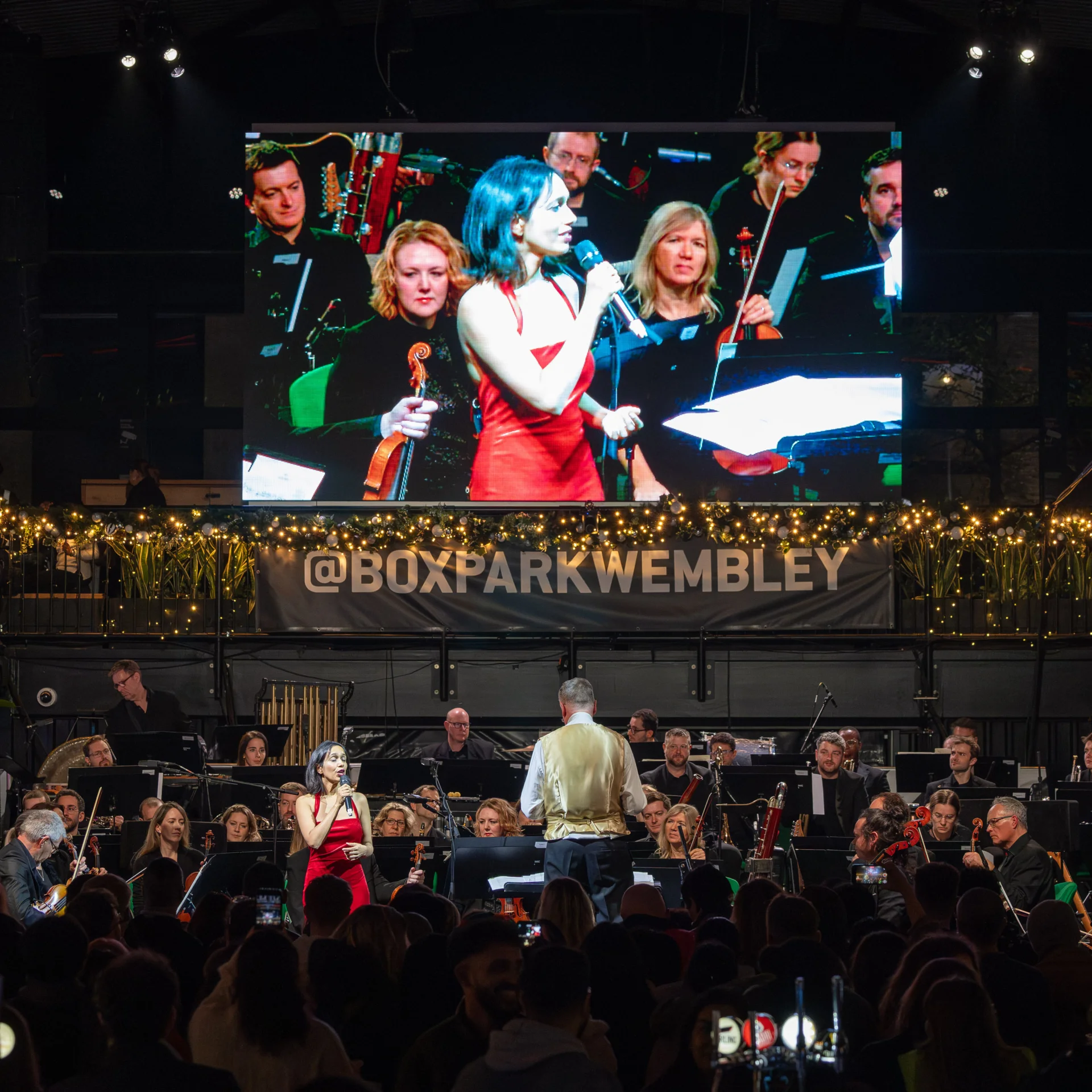 Singer Sumudu is shown on the big screen at Wembley Park, the RPO are on a stage with her below the screen, being conducted by Steve Bell