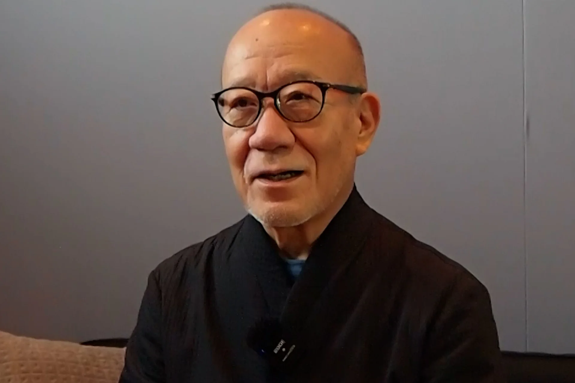 Joe Hisaishi wearing a black shirt talking