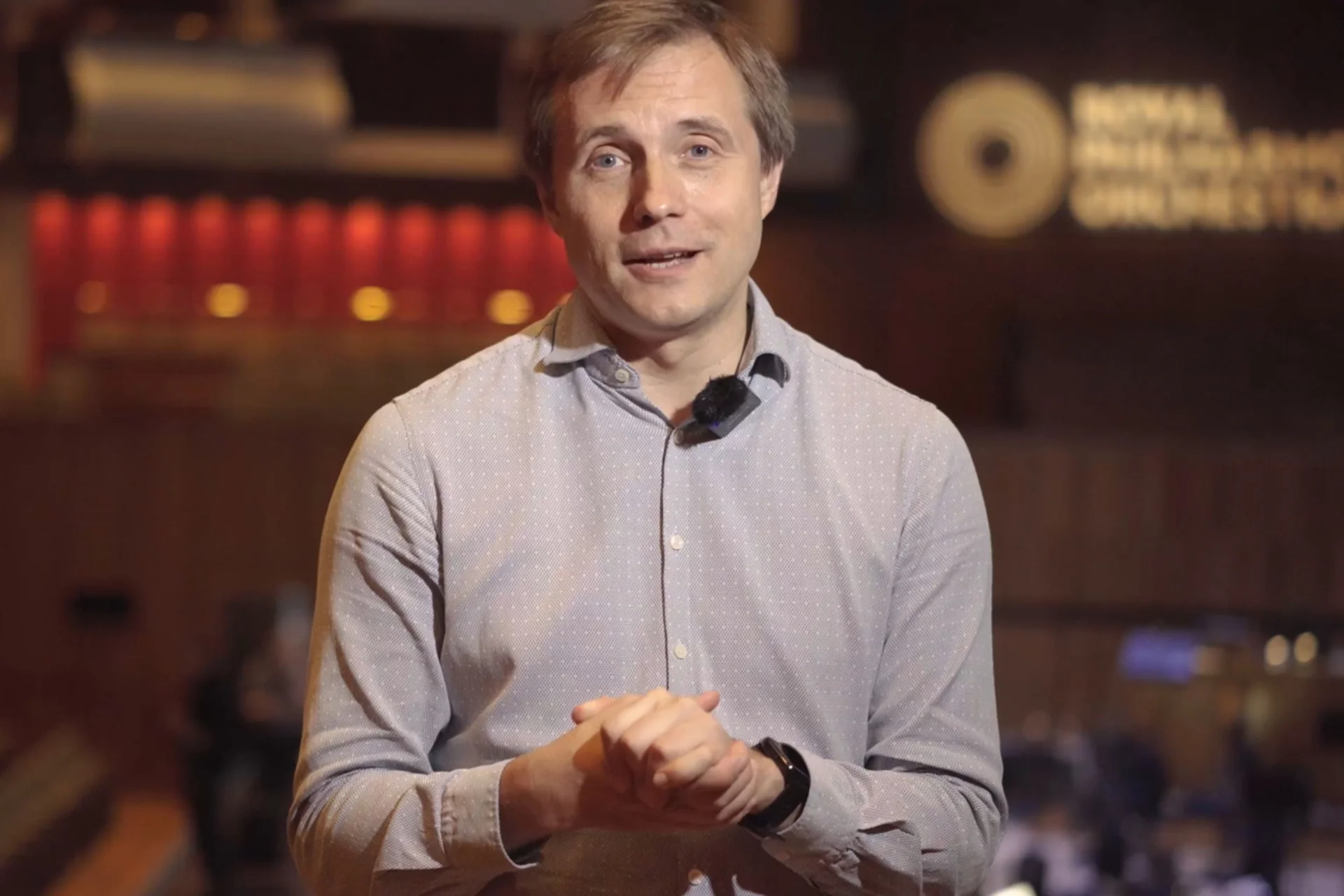 Muaic Director Vasily Petrenko faces the camera in a grey shirt, speaking about the RPO 80th Anniversary concert
