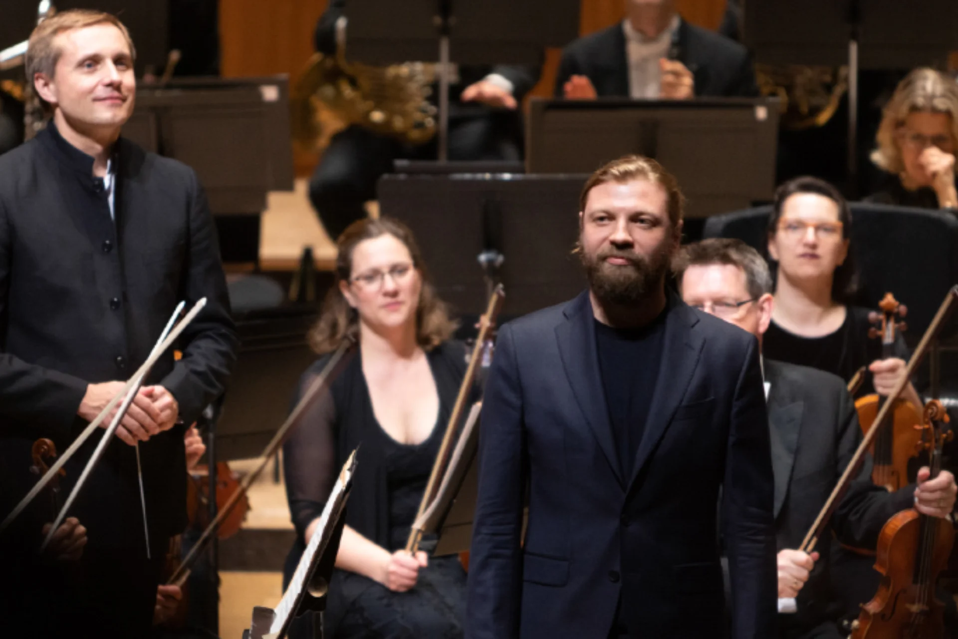 Vasily Petrenko and Denis Kozhukhin standing on stage to receive applause with the Orchestra behind them.