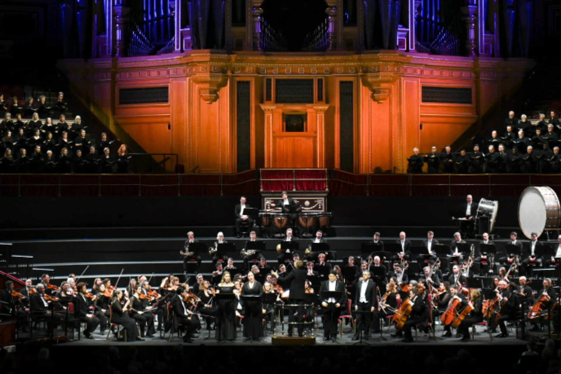 The Royal Philharmonic Orchestra performing on stage with the Philharmonia Chorus behind and above them in the choir stalls.