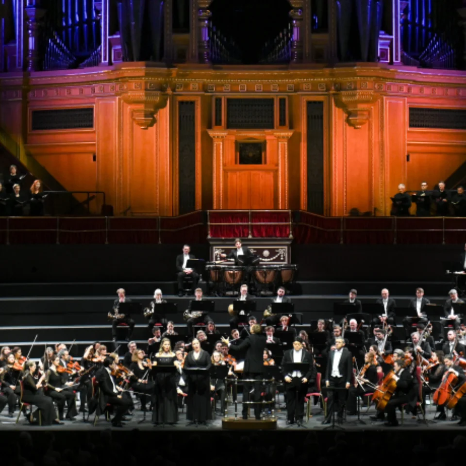 The Royal Philharmonic Orchestra performing on stage with the Philharmonia Chorus behind and above them in the choir stalls.