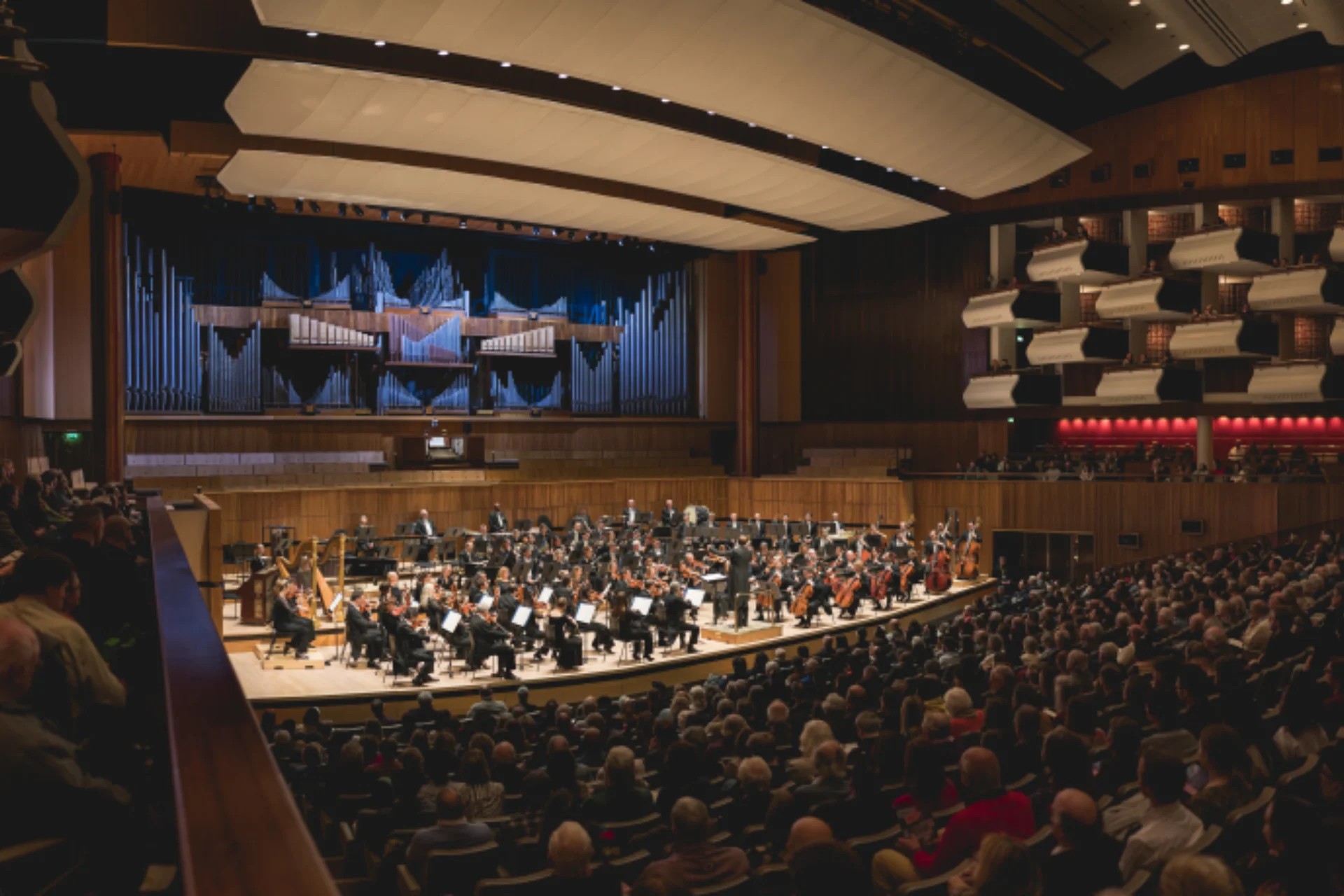 Orchestra playing to an audience in a large concert hall