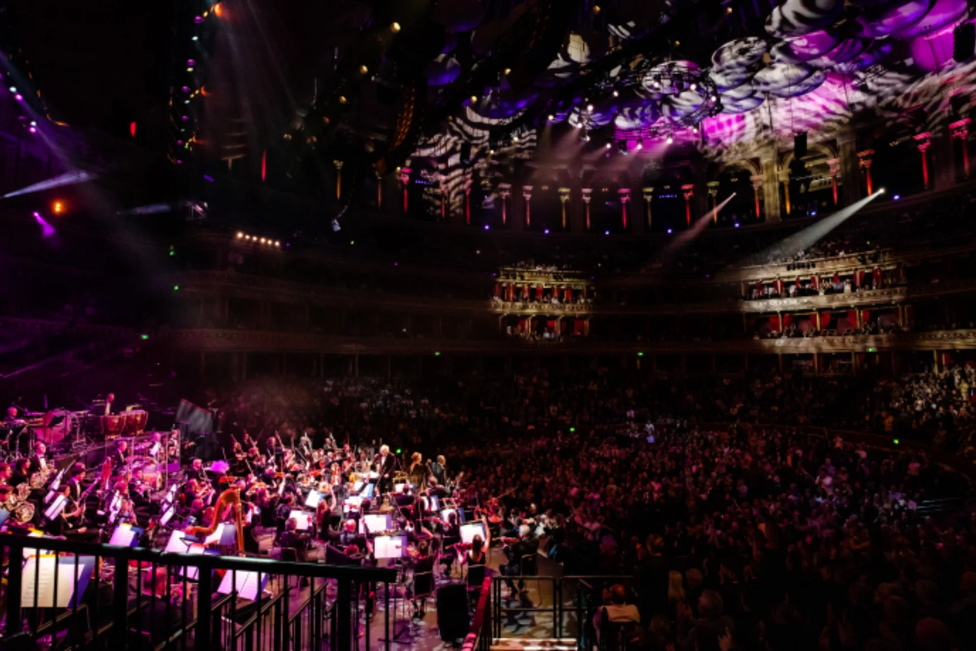 Orchestra playing in front of an audience in a large concert hall