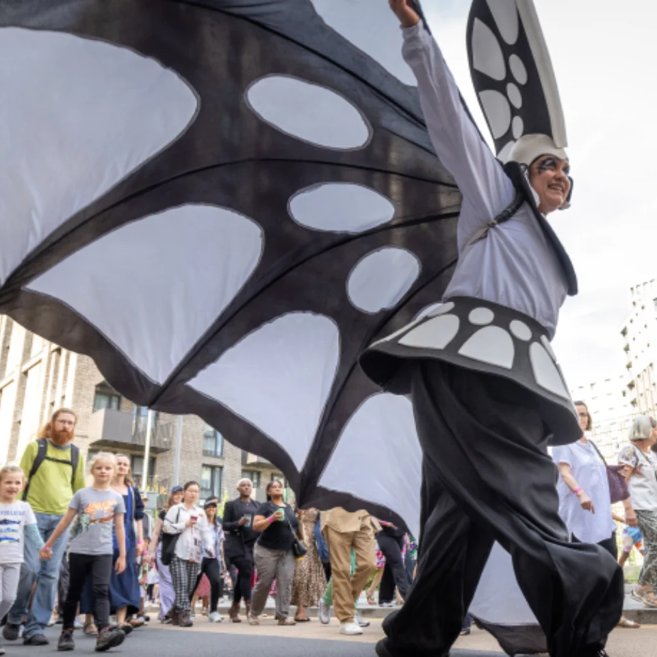 A person in a blcak and white butterfly carnival costume in Wembley Park