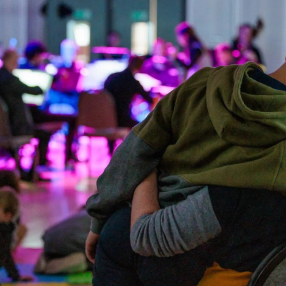 Two people hugging and watching orchestra performance
