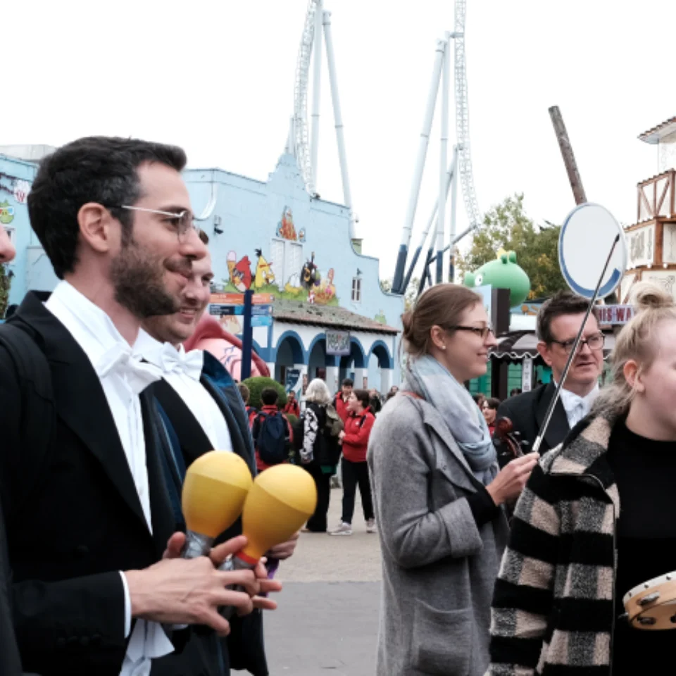 Orchestra players outside holding instruments