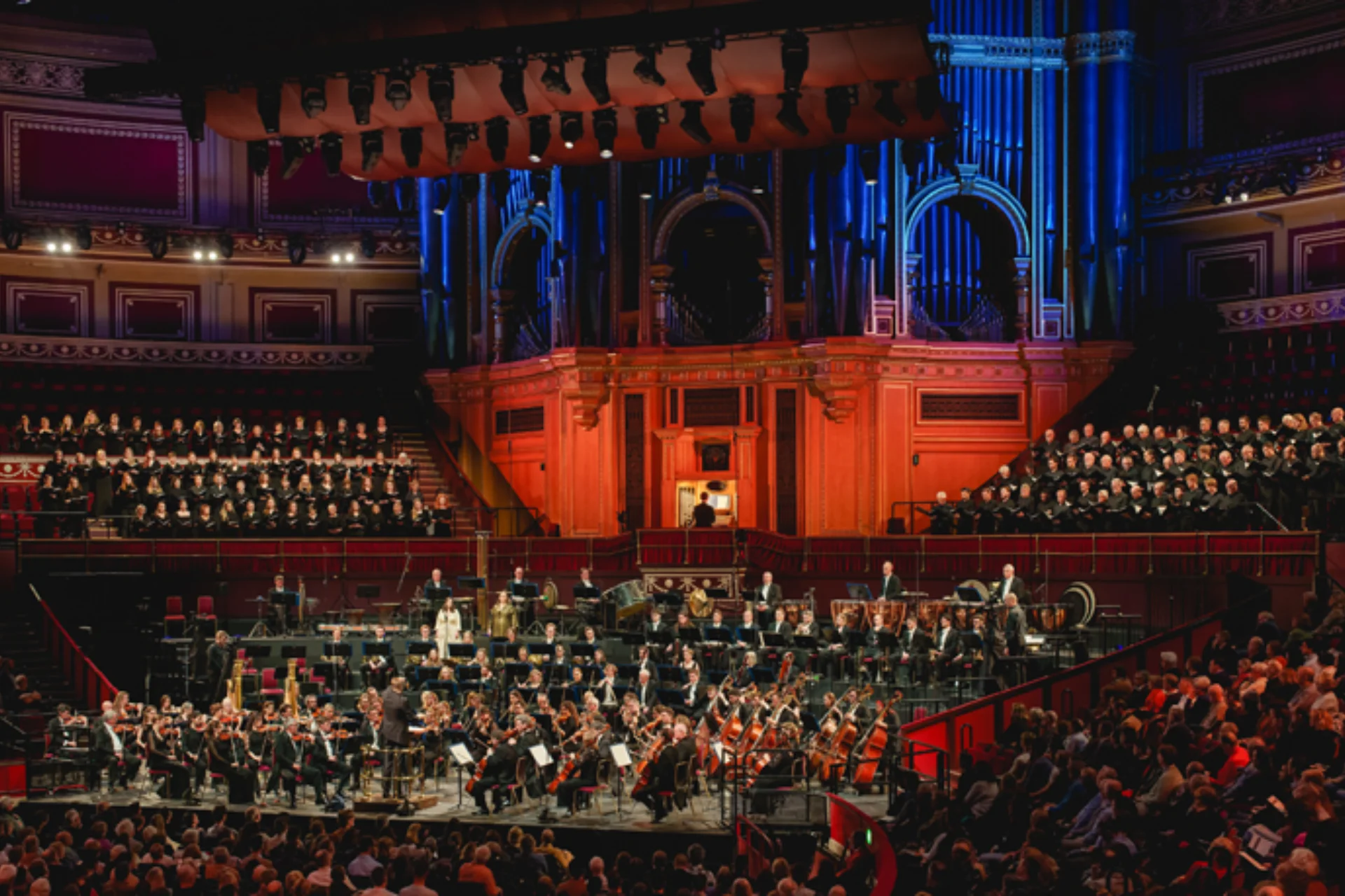 Orchestra playing in front of an audience in a large concert hall