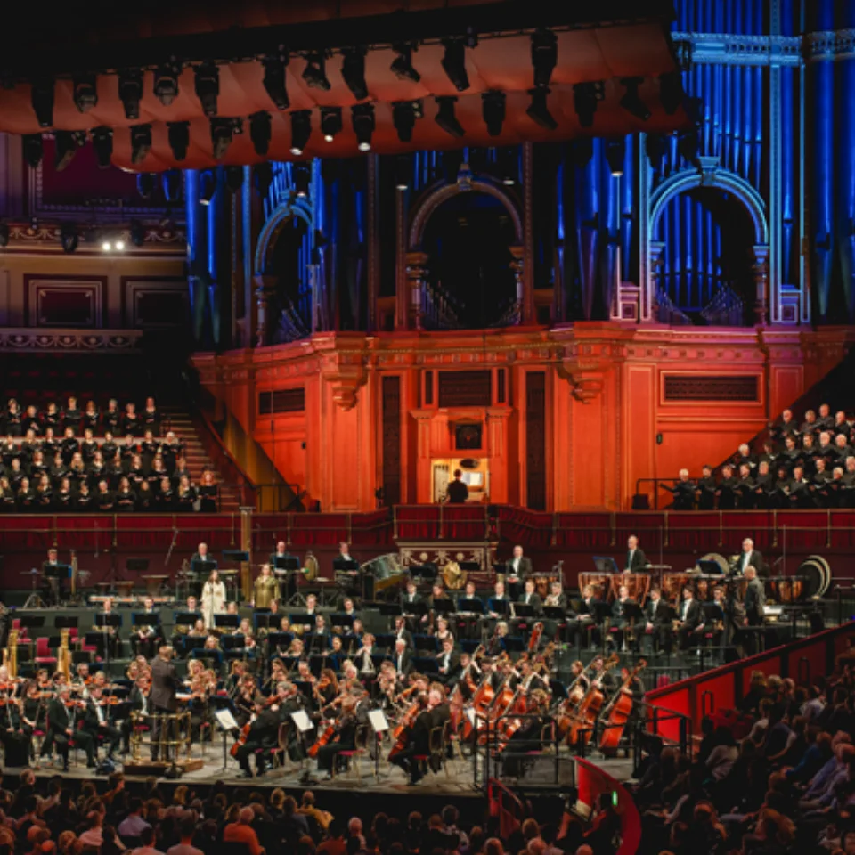 Orchestra playing in front of an audience in a large concert hall